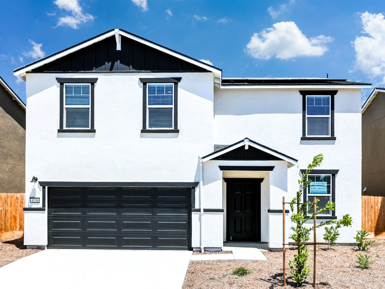 A white house with a black garage.