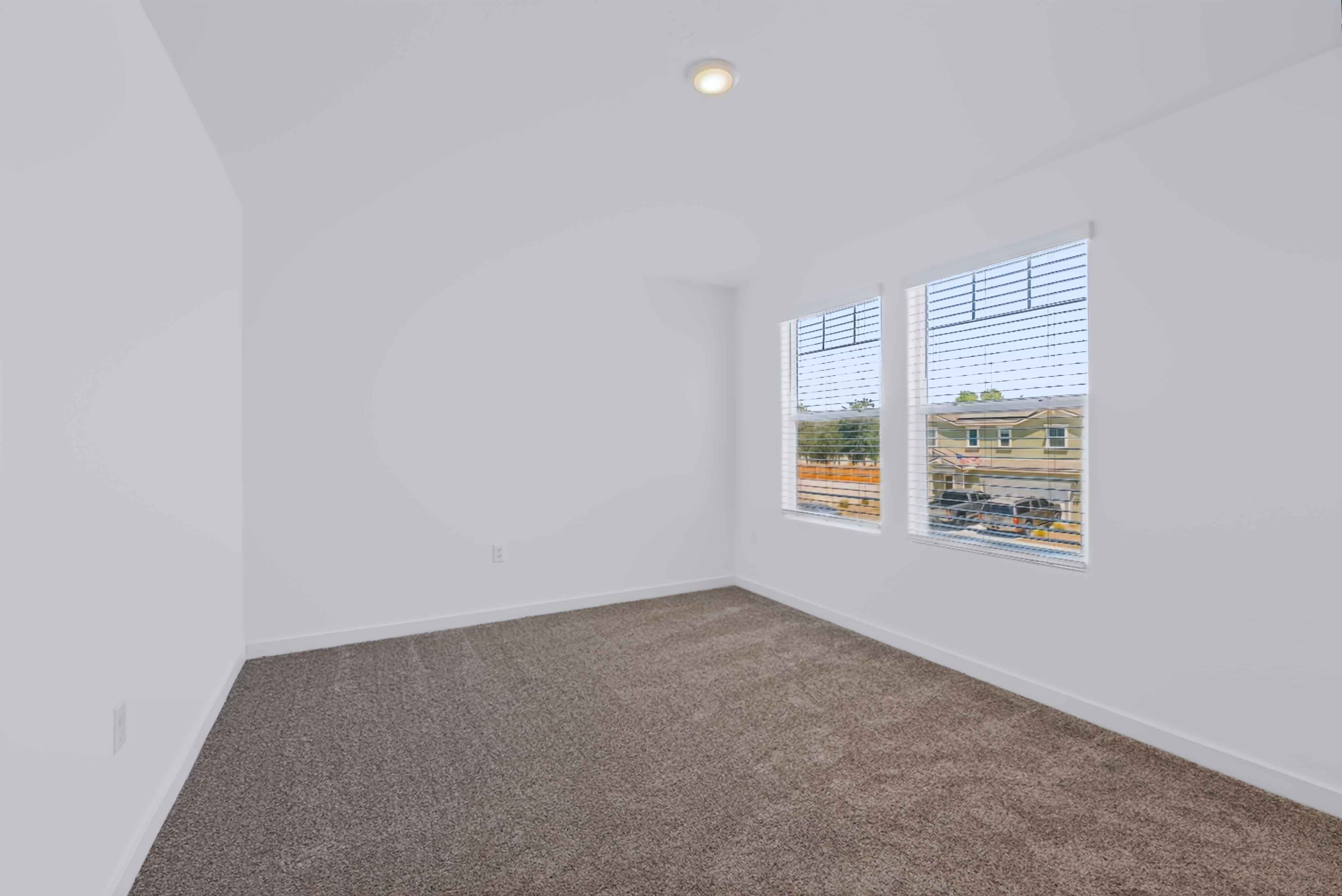 A room with a window and a carpet.