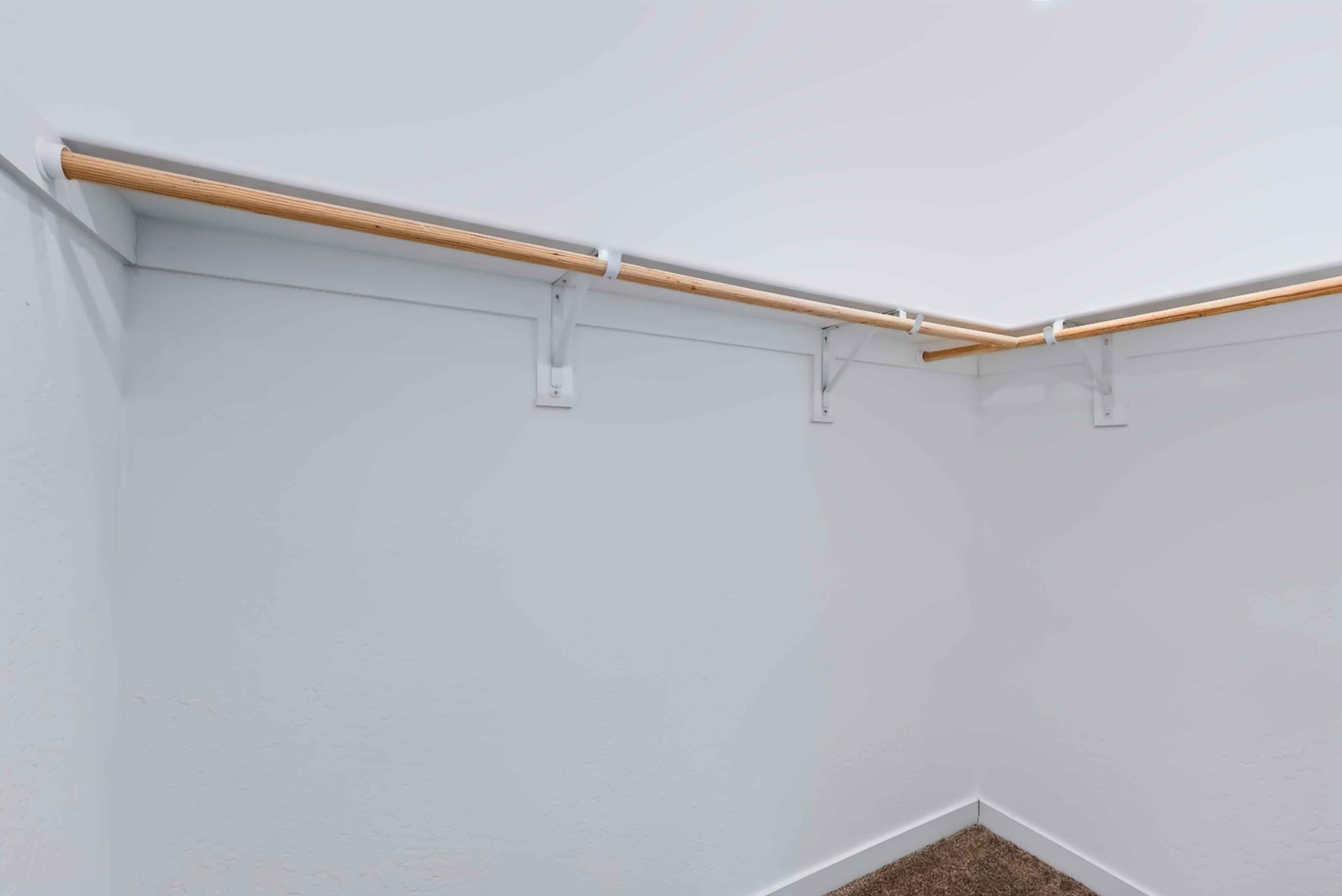 A wooden pole with a white wall.