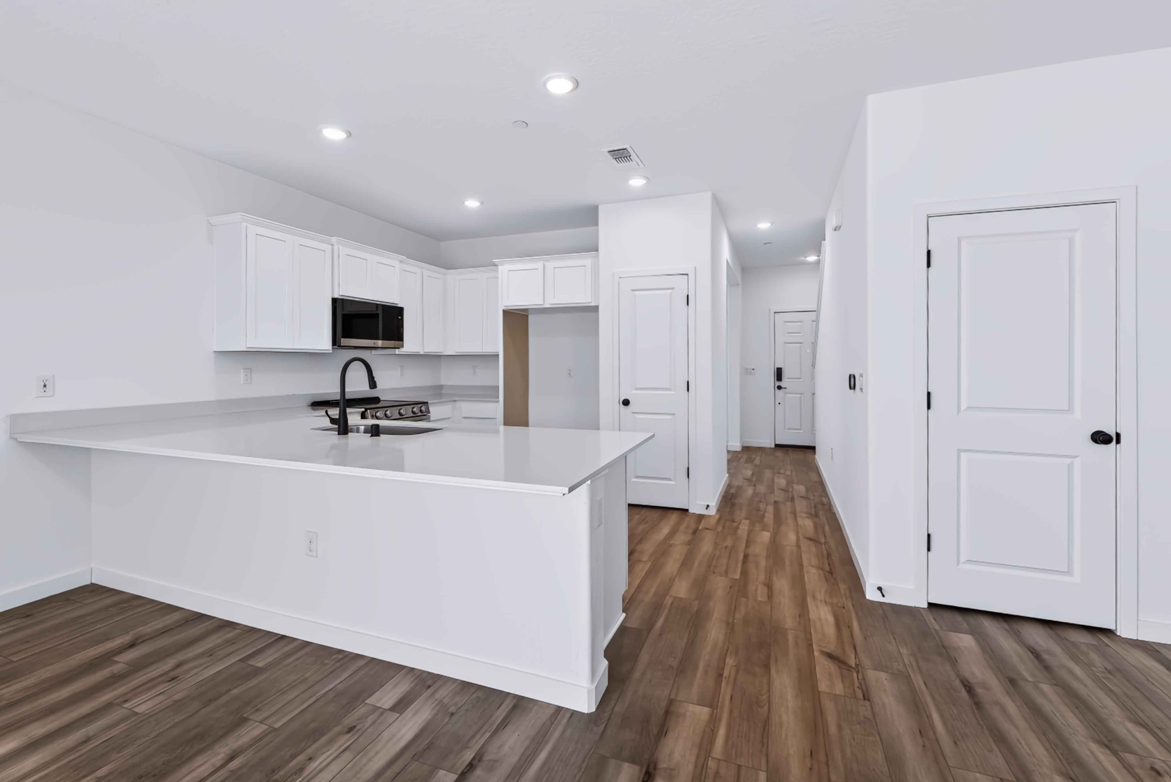 A kitchen with white cabinets.