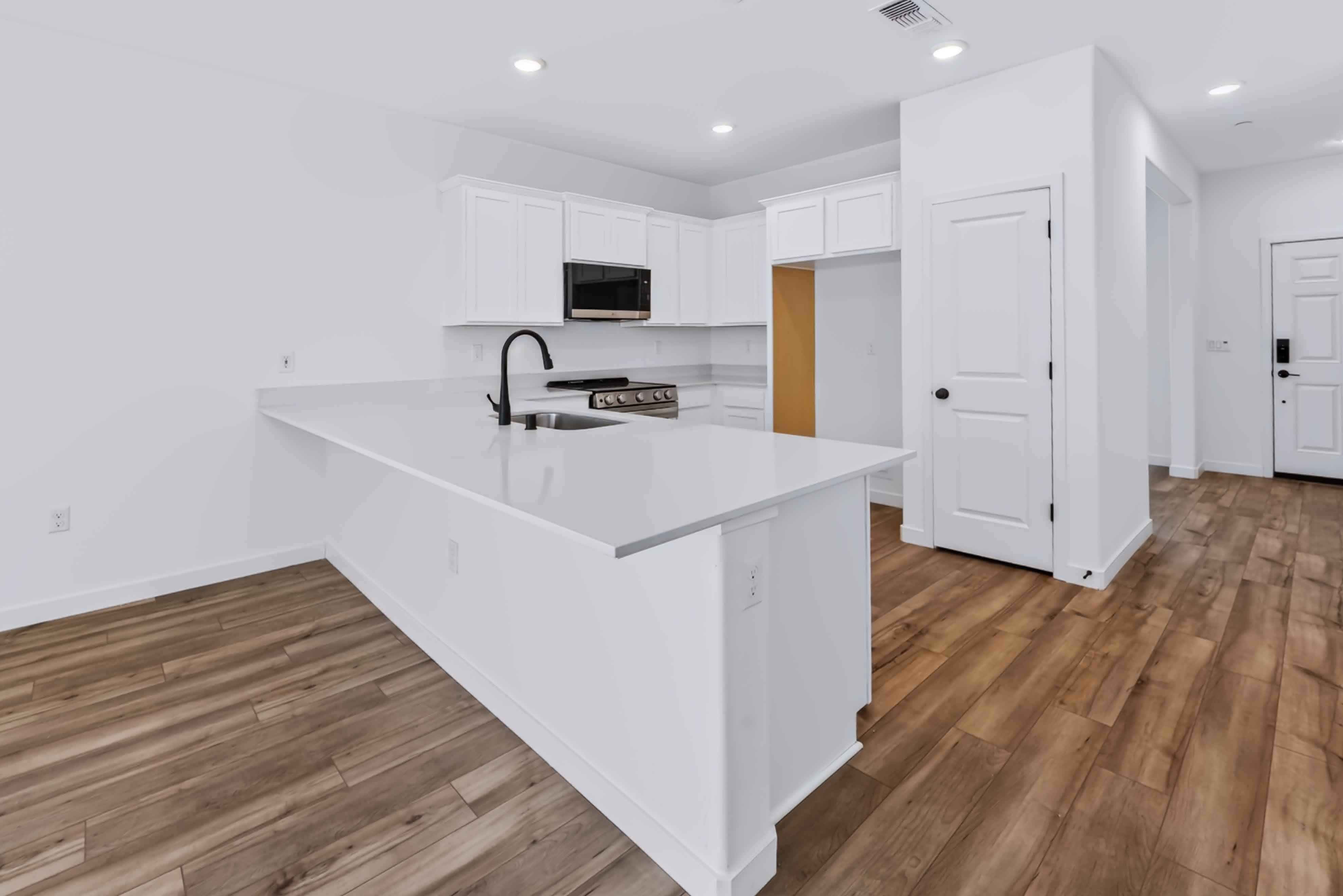A kitchen with white cabinets.