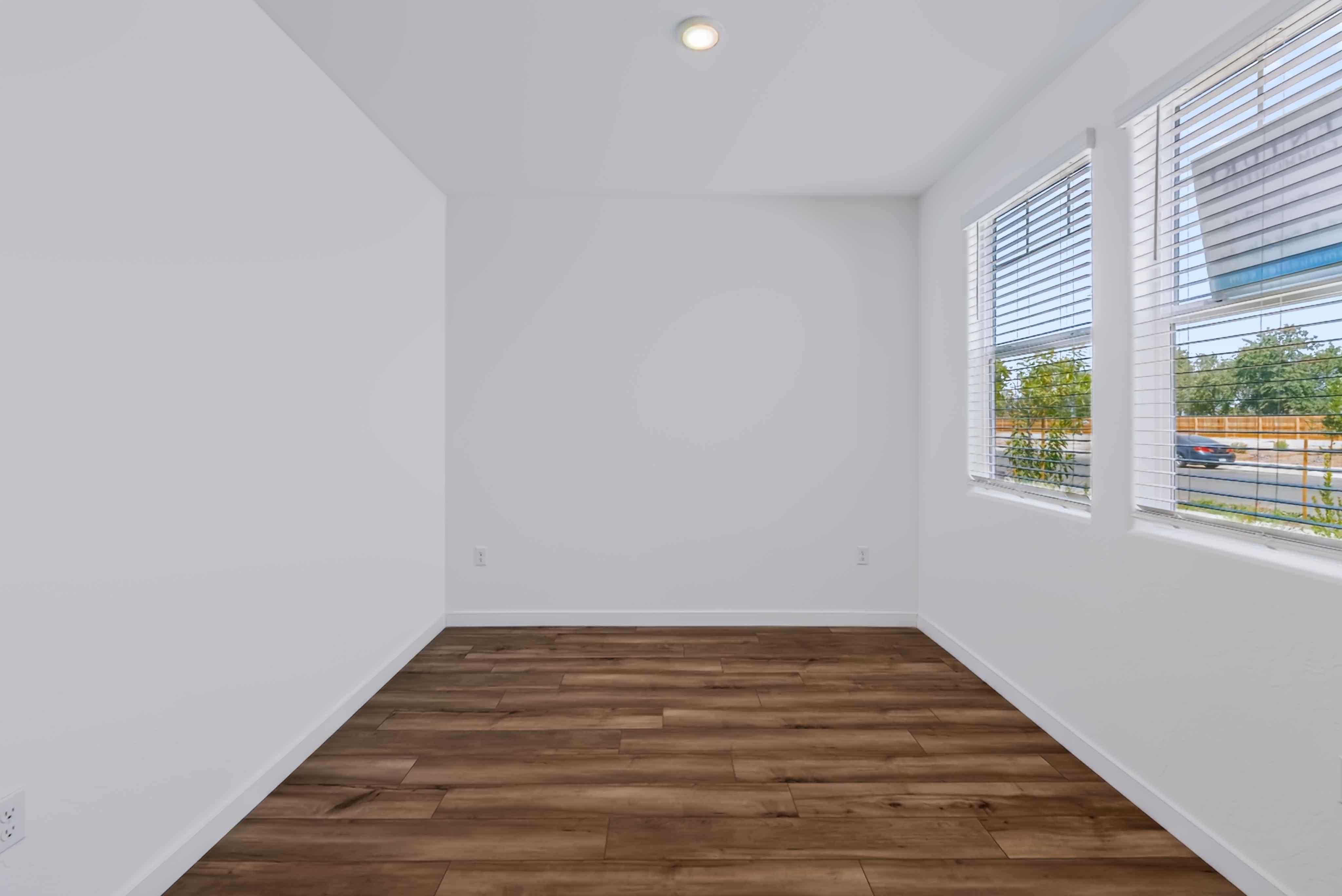A room with a wood floor and windows.