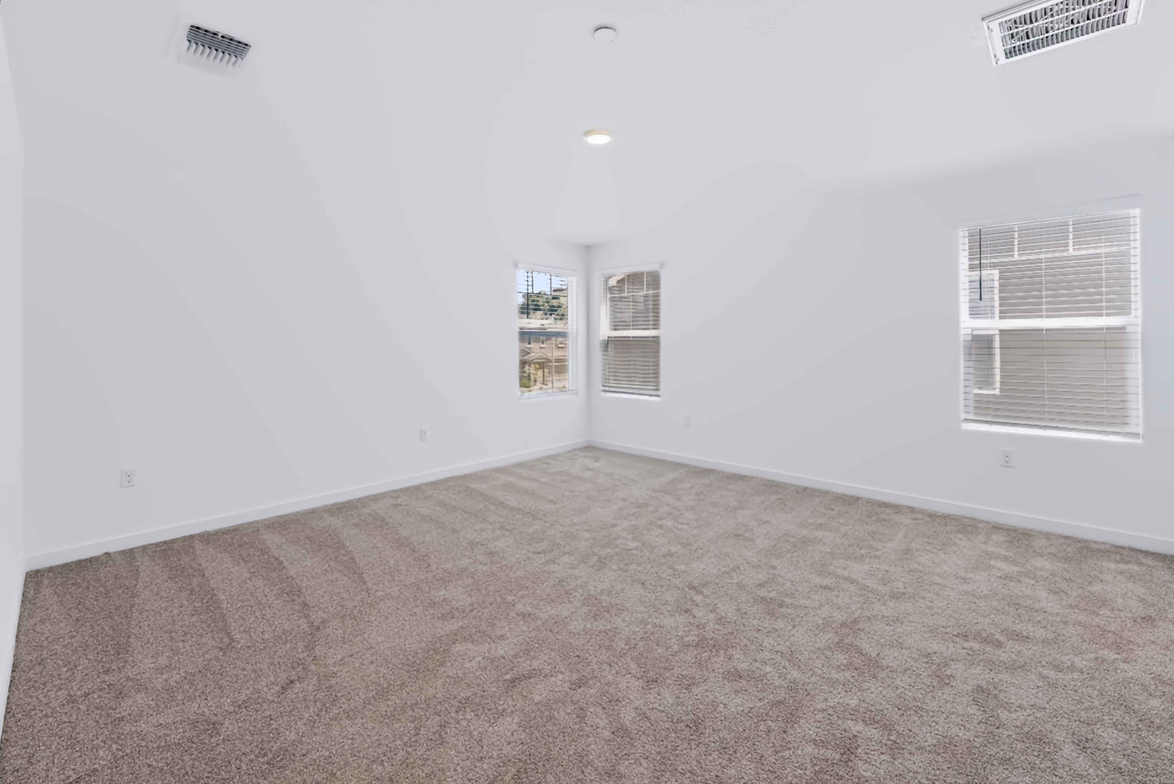 A room with a carpet and windows.
