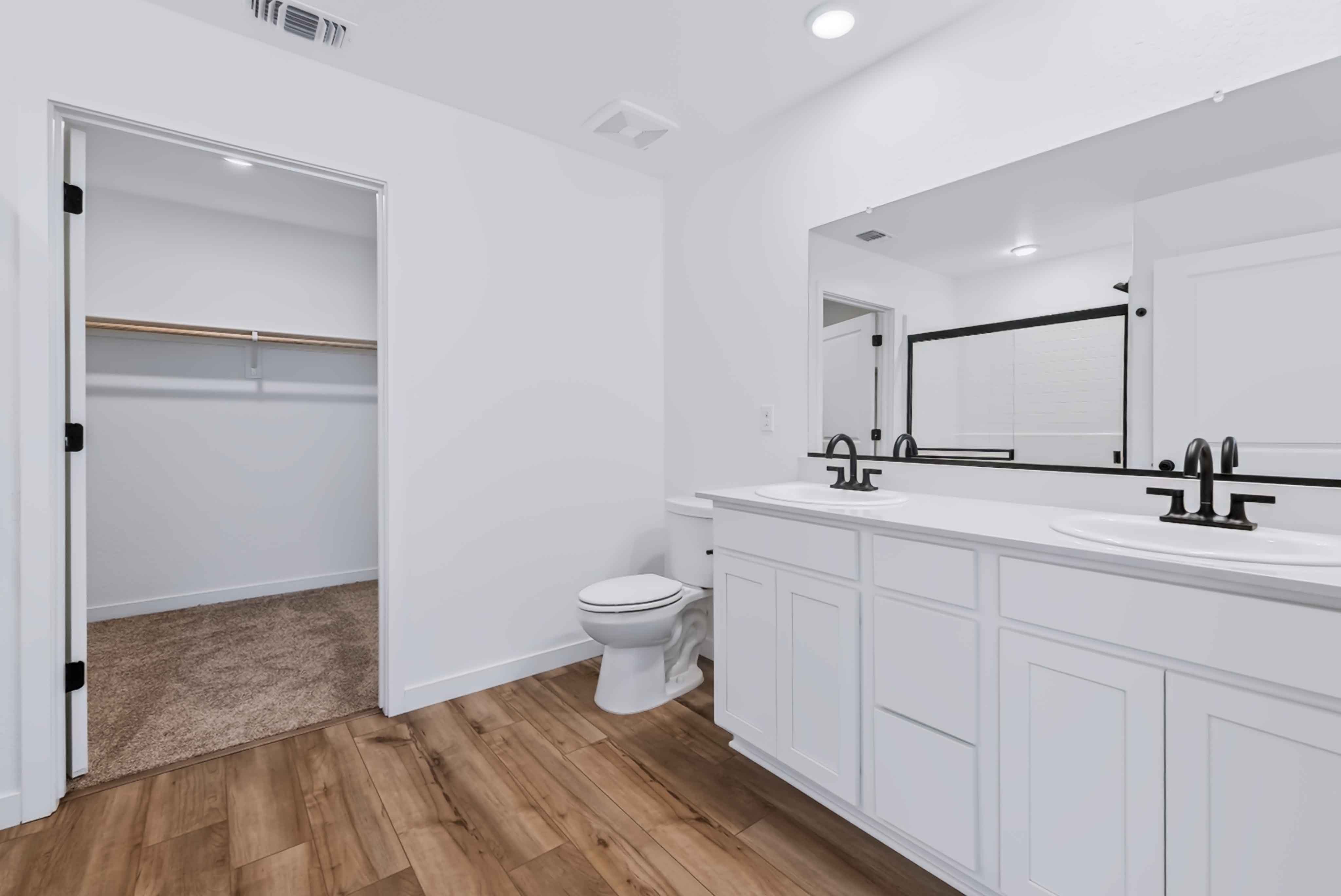 A bathroom with white cabinets.