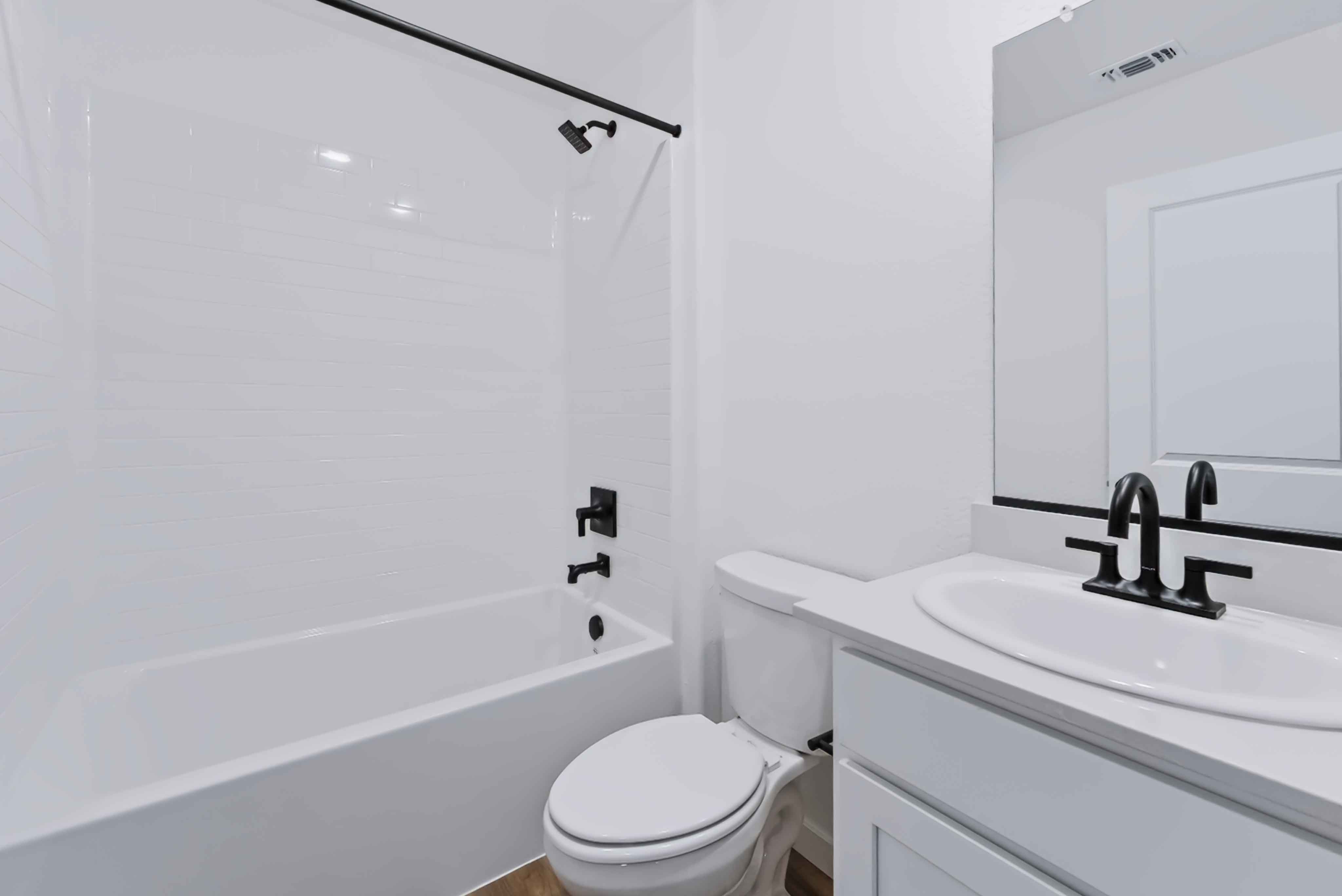 A bathroom with a sink toilet and bathtub.