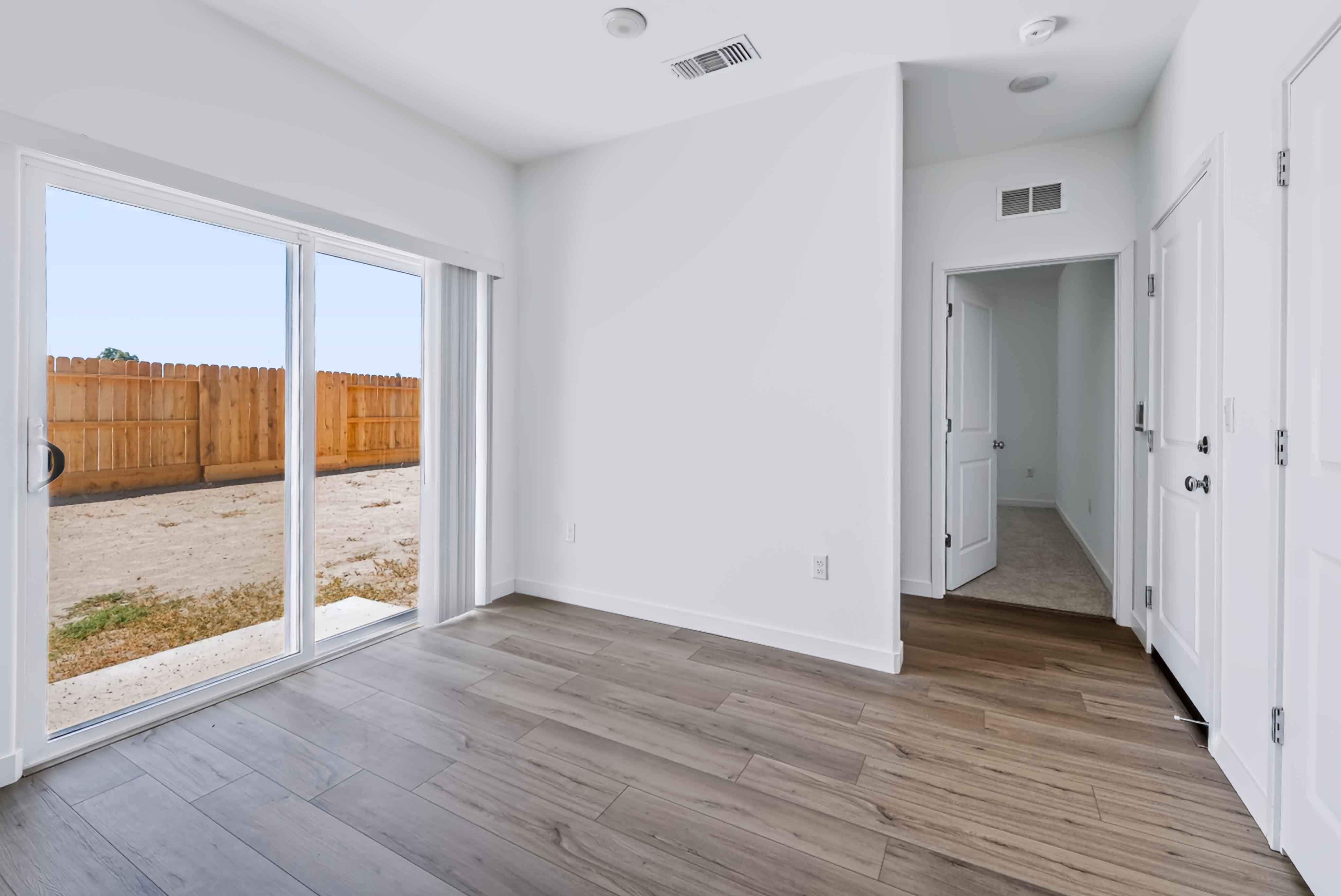 A room with white walls and wood floors.