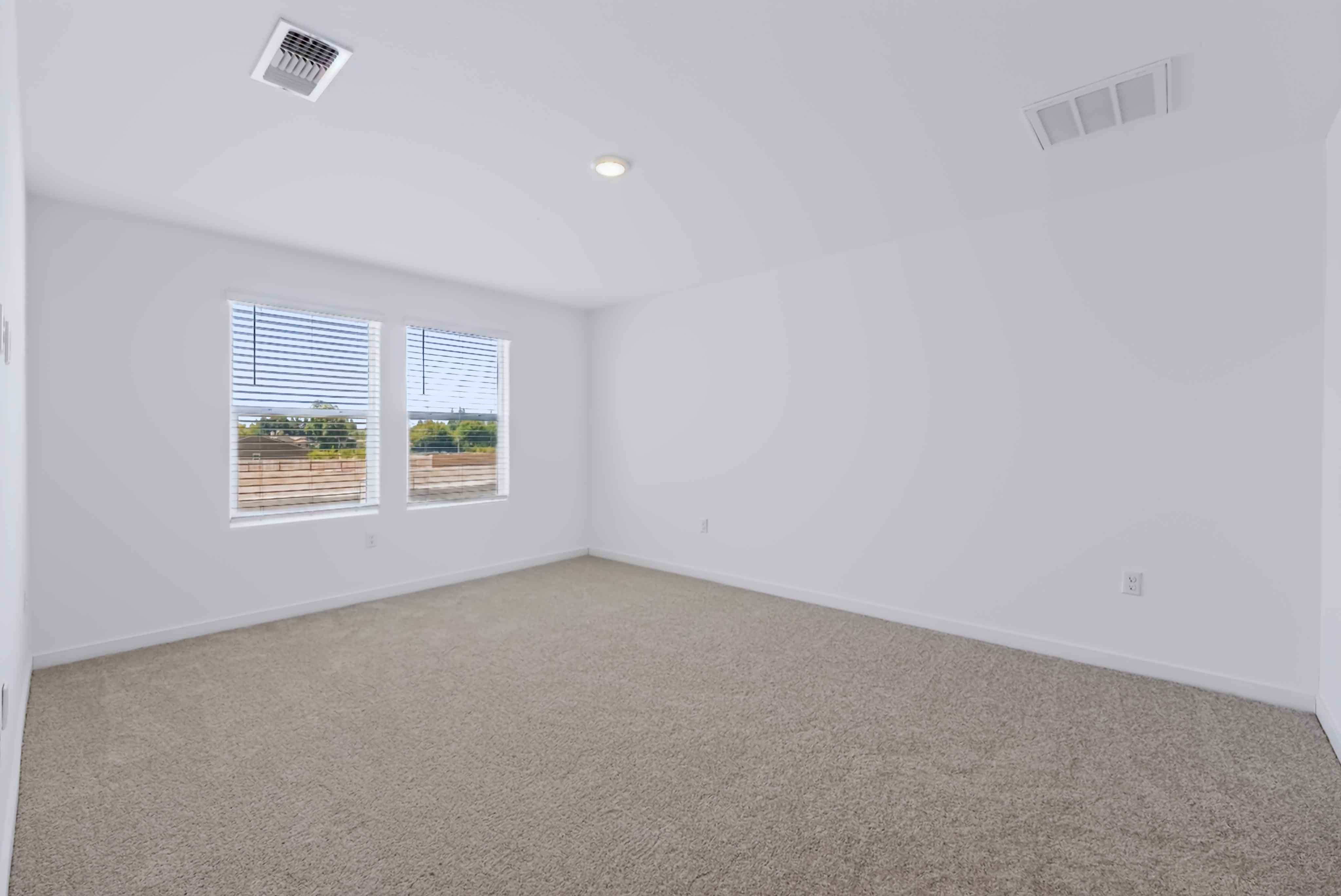 A room with a carpet and windows.