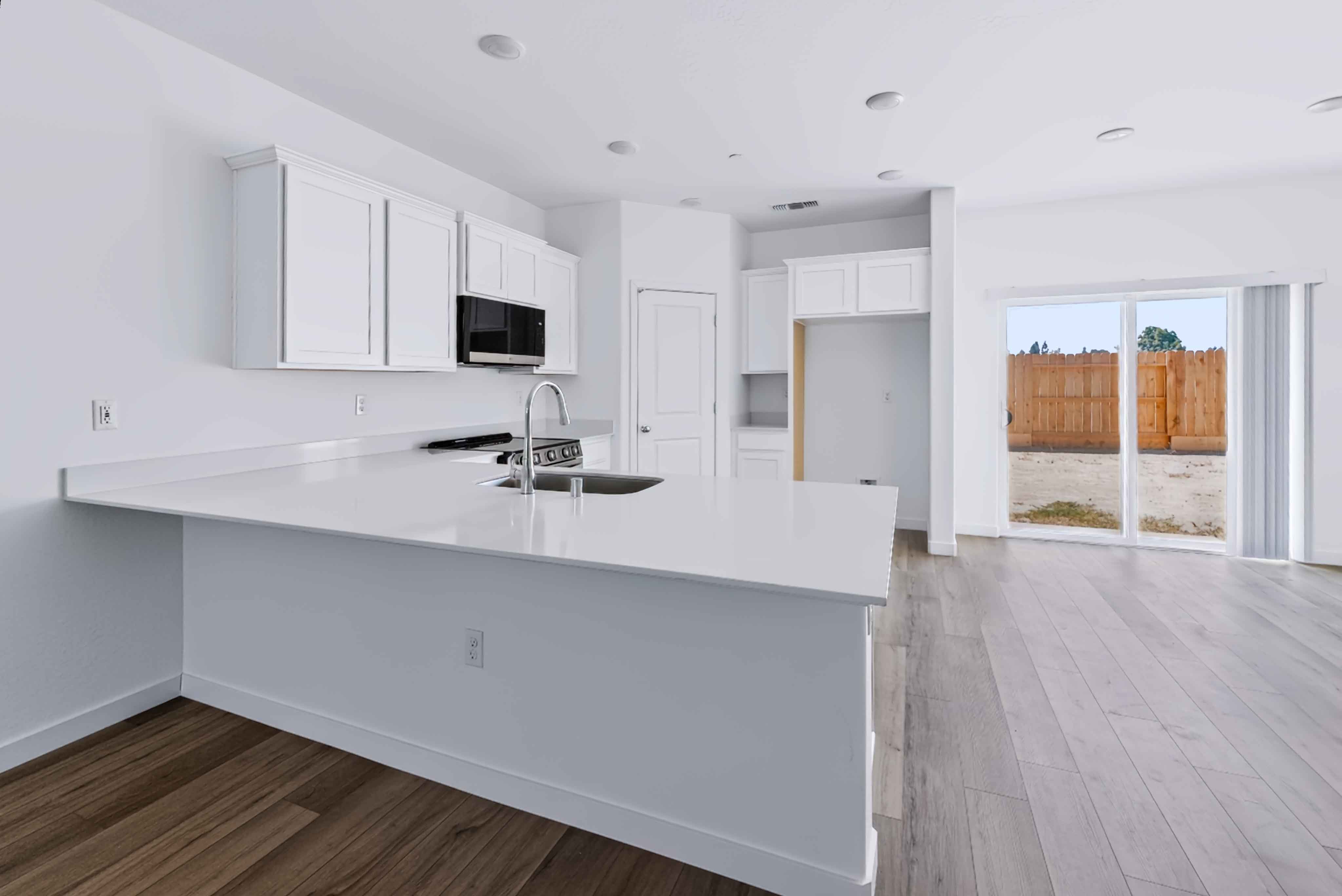 A kitchen with white cabinets.