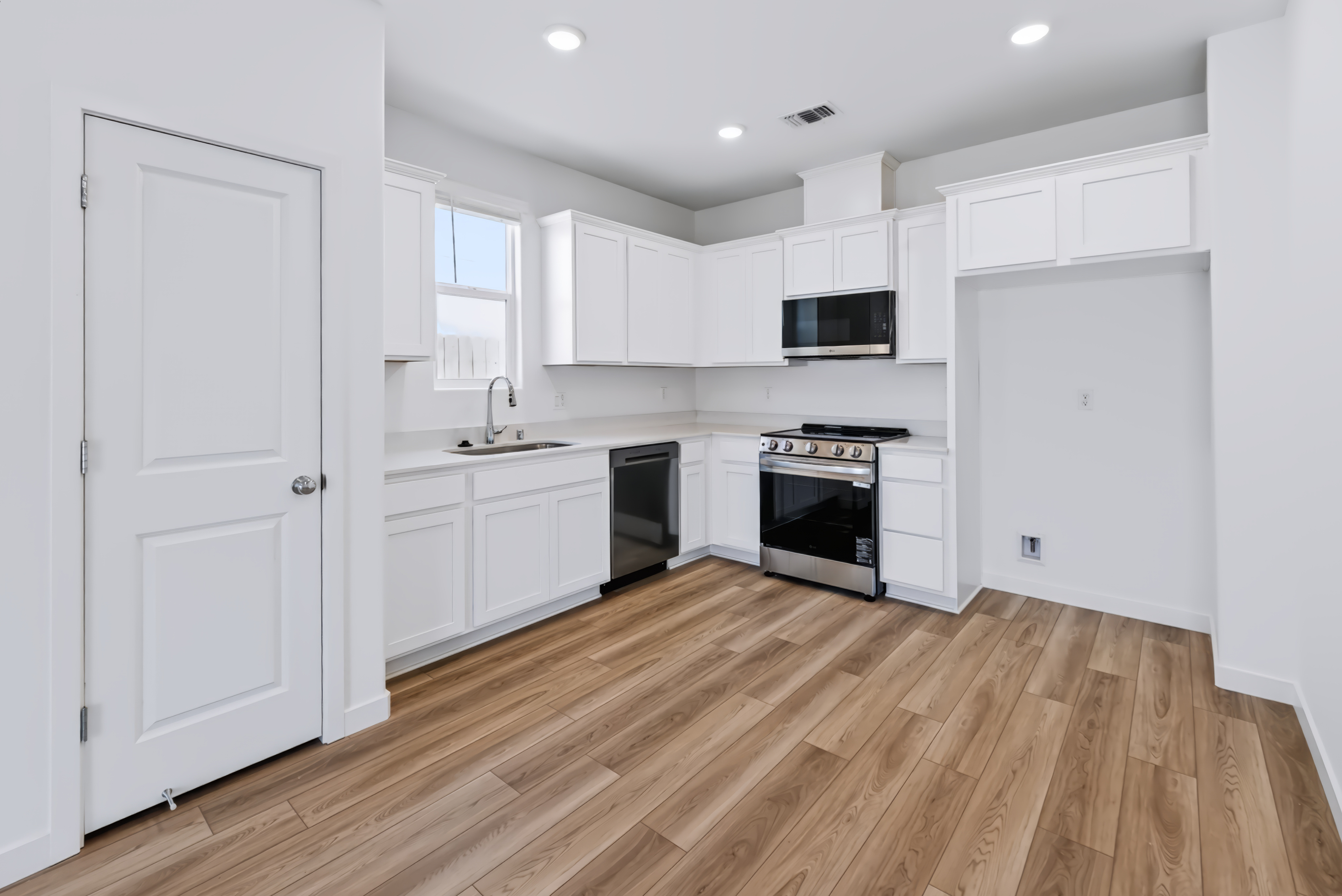 A kitchen with white cabinets.