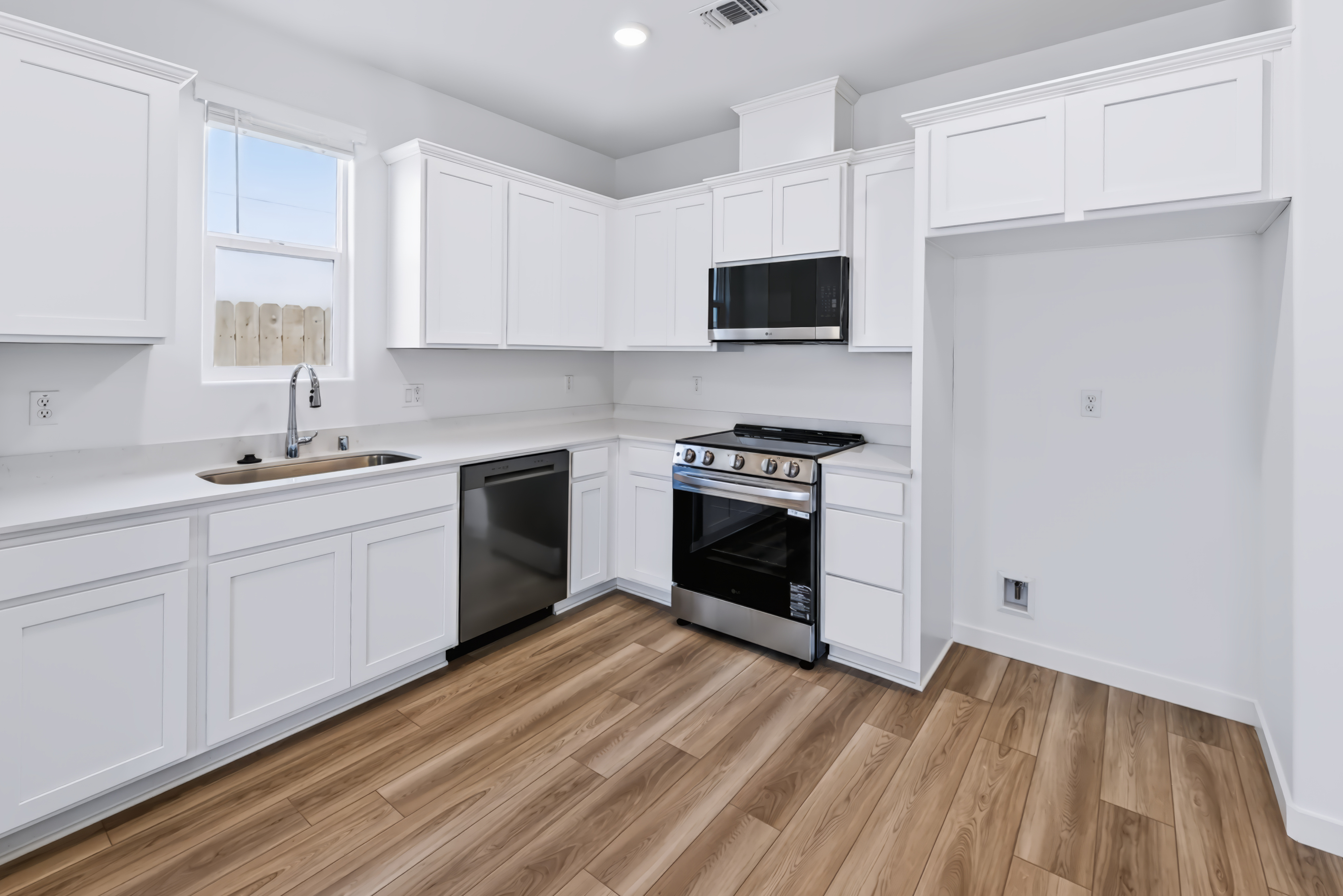 A kitchen with white cabinets.