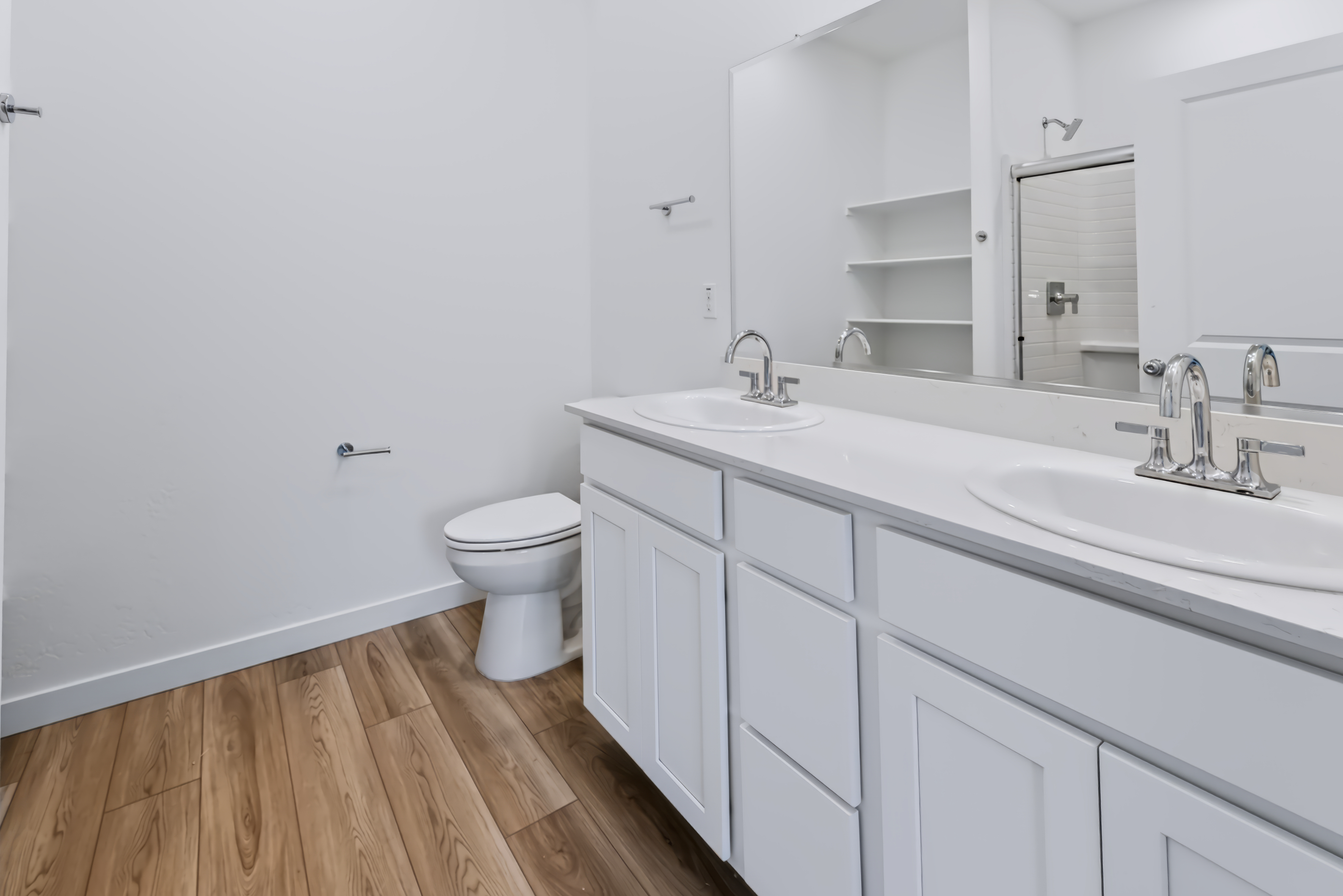 A bathroom with white cabinets.