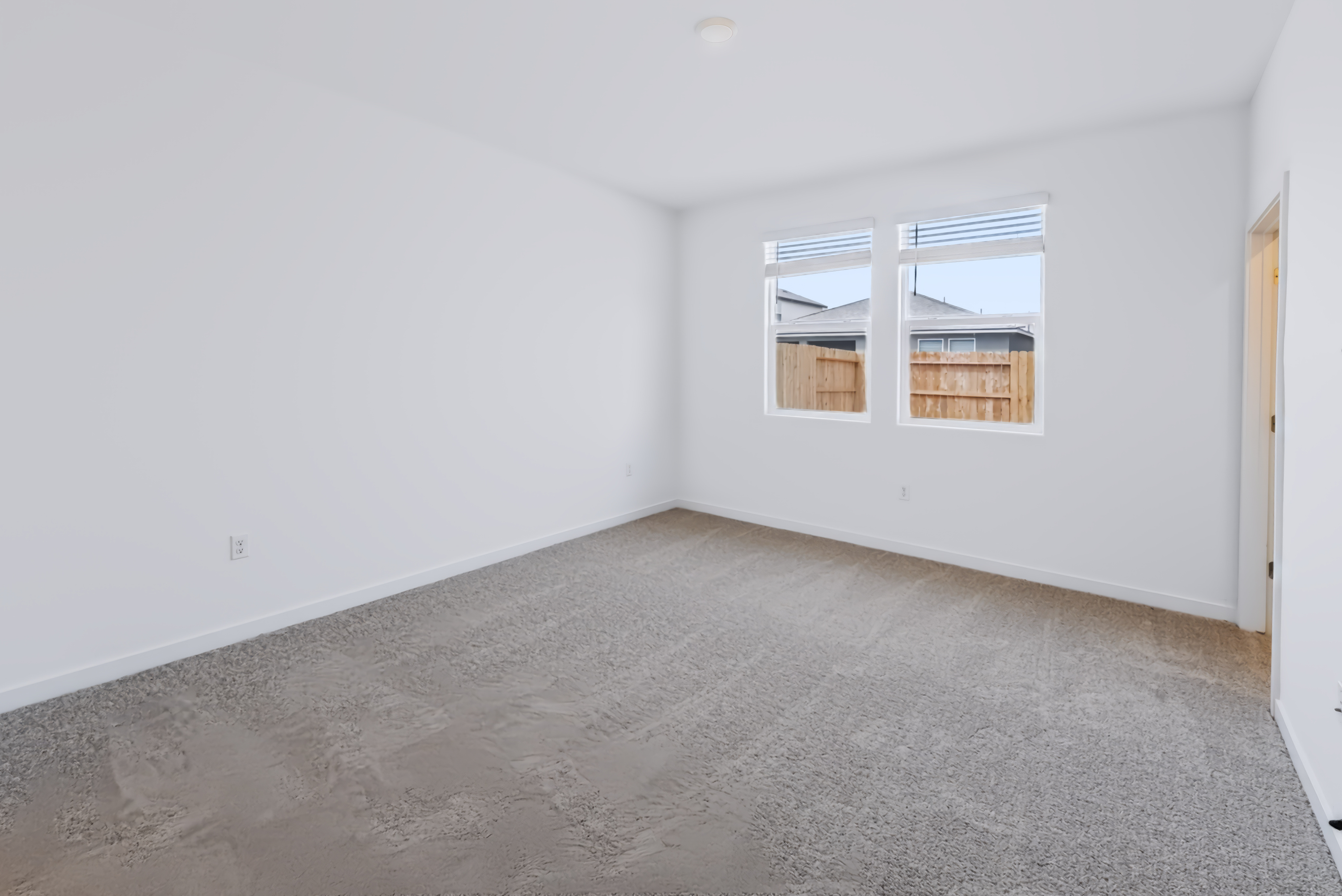 A room with a carpet and a window.