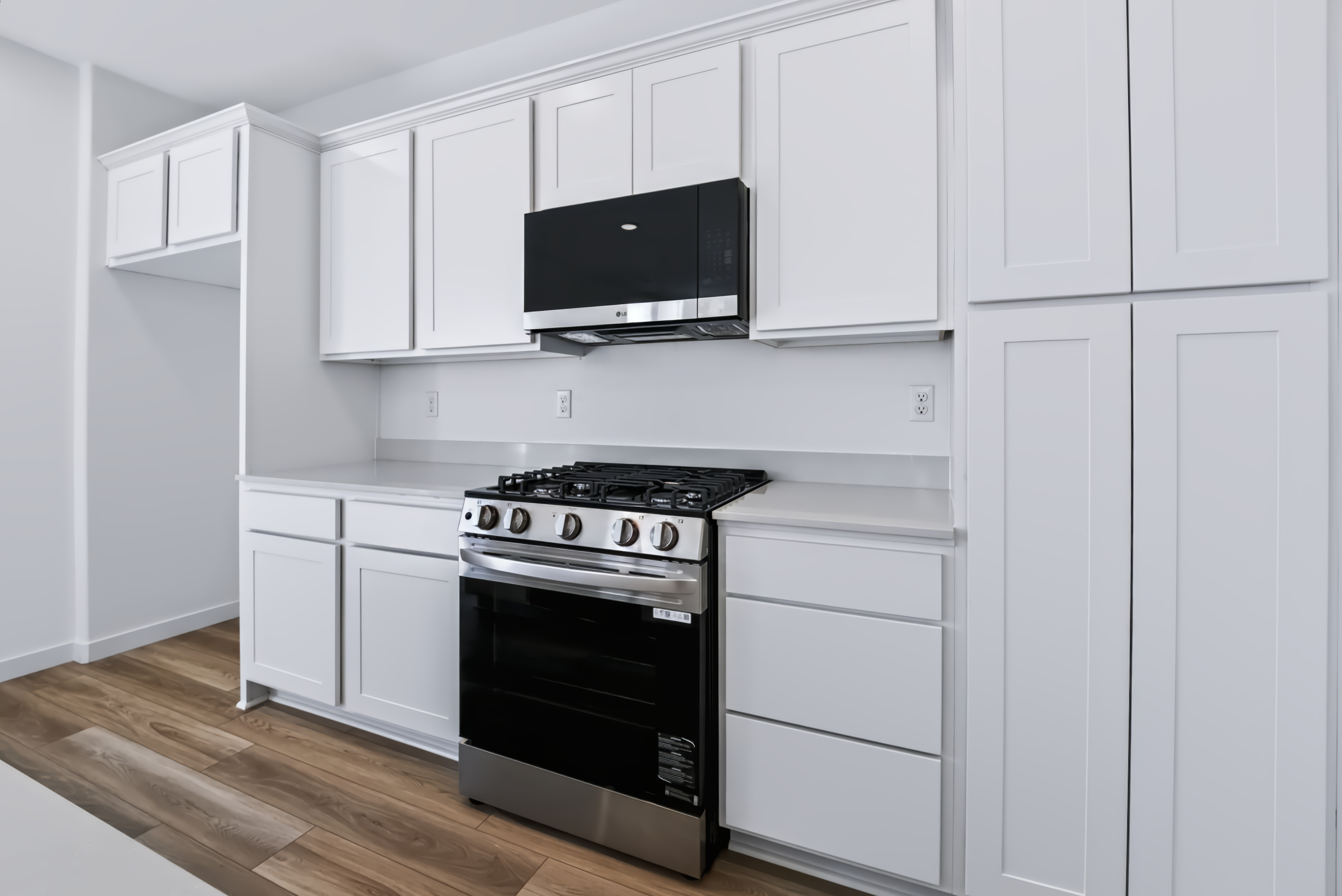 A kitchen with white cabinets.