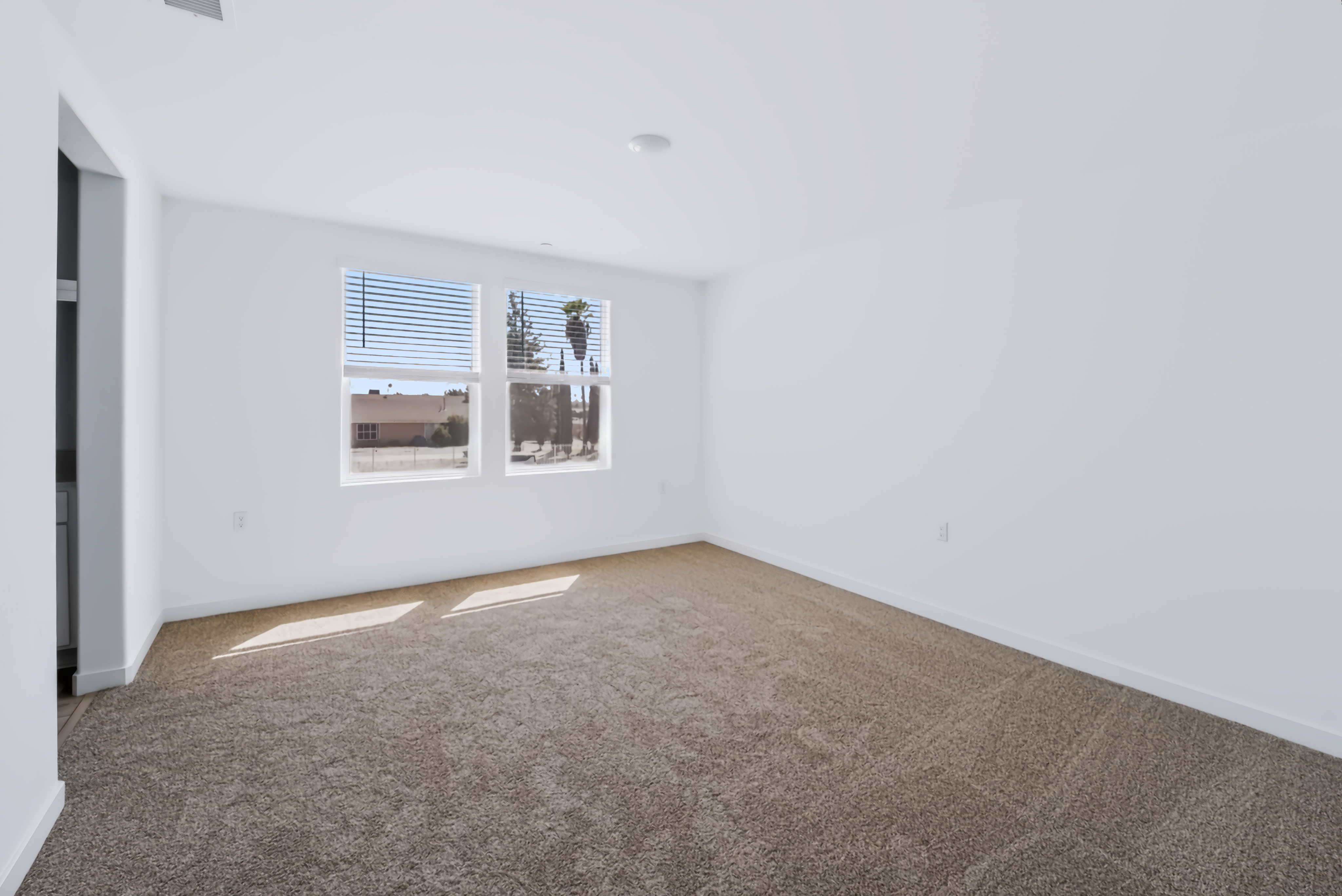 A room with a carpet and a window.