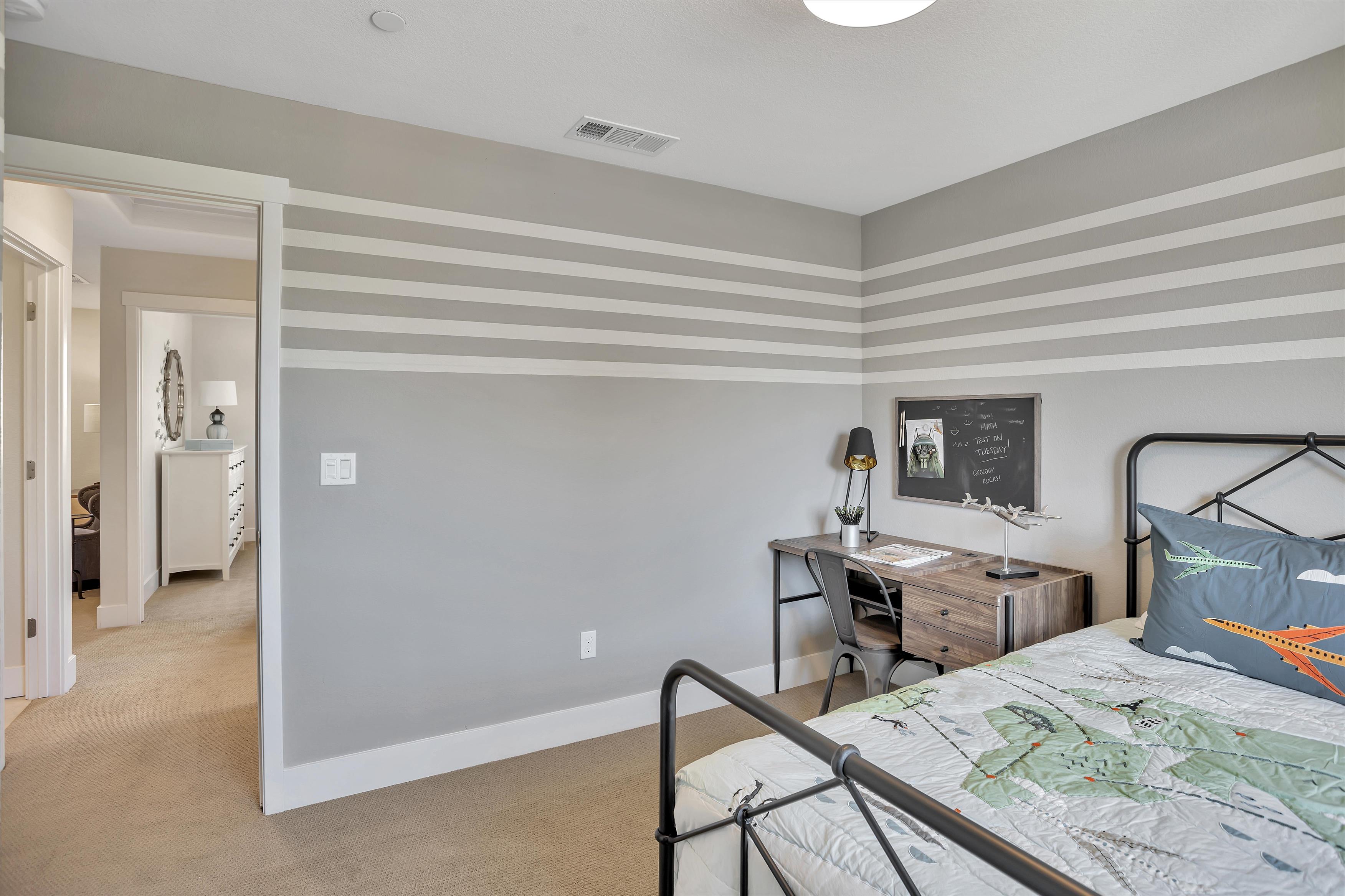 A bedroom with a bed desk and a tv.